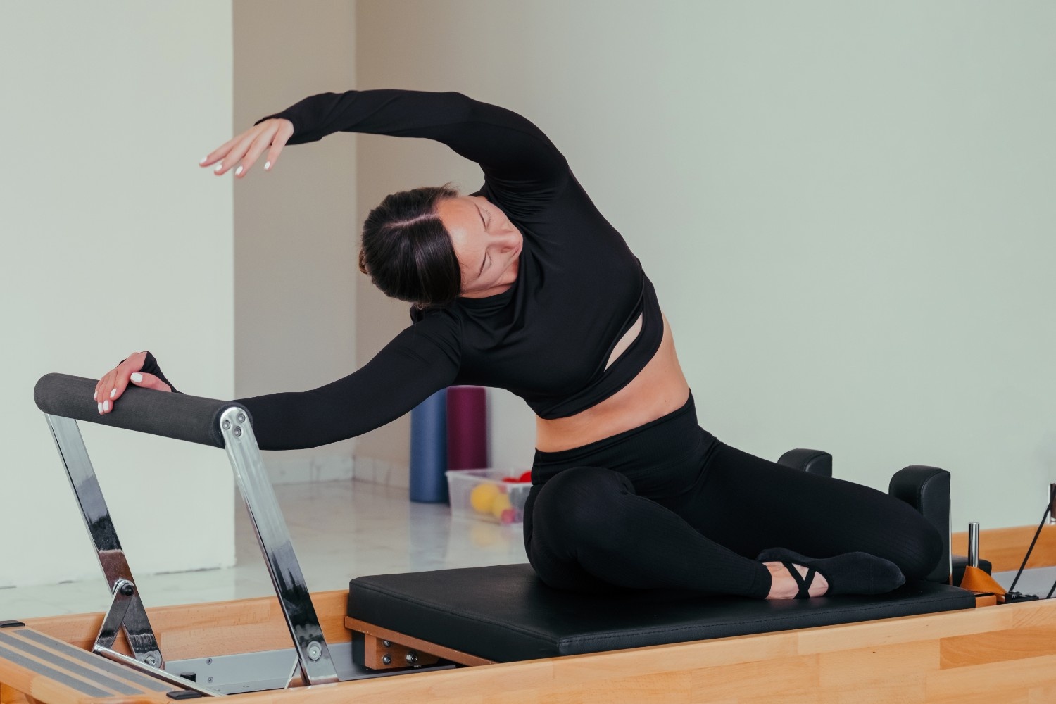 Person stretching at desk to relieve tension with Pilates movements